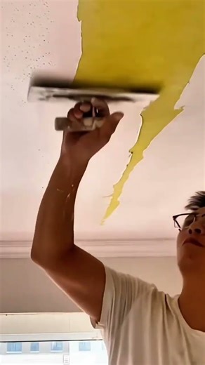 A precise ceiling finishing process where fresh plaster is smoothed evenly to create a clean and