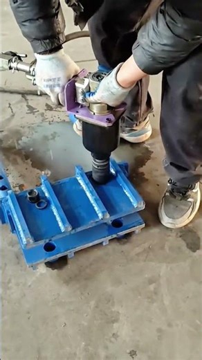 operating an industrial pneumatic torque wrench to tighten large bolts on a heavy metal base plate