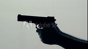 Hand with a gun shooting. Violence and crime with use of fire weapon, back lit silhouette