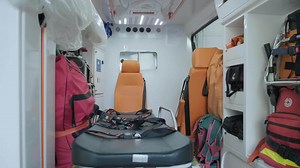 Inside the ambulance, view from the sanitary compartment. Different medical equipment and a stretcher.