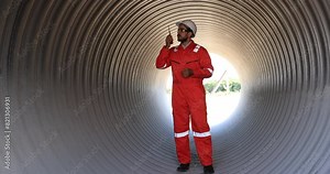 Mechanical engineer with safety uniform work in side huge pipe at construction siteline
