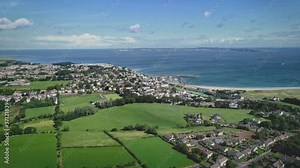 Ireland ocean bay town aerial view: port Ballycastle, Northern. Houses with cottages and city roads. Beautiful ships, yachts and boats in bay waters. Summer day scenery zoom shot in 4K, UHD