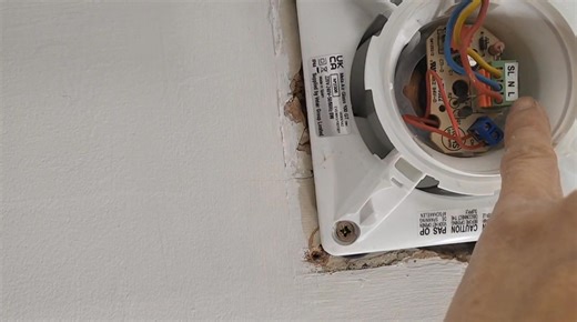 在英國的浴室抽氣扇（Extractor Fan）安裝中，即使風扇本身是「雙重絕緣（Double Insulated）」並不需要接地線（Earth），你仍然常常會看到有三條線連接到它。這三條線各自有不同的功能，原因如下👇： 為什麼有三條線接駁？ 如果是**帶定時功能（Timer type）**的抽氣扇，它需要： • Permanent Live（常電）來維持延時運作（例如關燈後繼續抽氣 2–5 分鐘） • Switched Live（開關電）用來觸發啟動 • Neutral（中線）完成電路 這樣即使燈關掉，風扇仍可繼續運轉一段時間後自動關閉。 🧰 而如果是「不帶定時」的基本型： • 只需要 Switched Live Neutral（2 線） • 但安裝電工常用 3 芯電纜（Brown, Blue, Earth），所以你仍會看到三條線，其中地線會被封起不接。 | Lee Hoi Leung Max