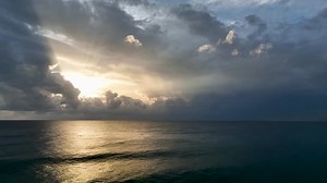 Aerial view flying through thunderclouds at sunset. 4K