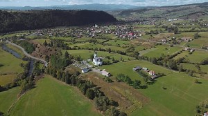 Sunny Afternoon Over Serene Countryside Village With Church and Rolling Hills in Europe