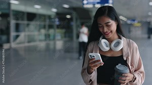 Stylish Woman in Casual Attire Scrolling Apps in Airport Terminal, Chatting on Phone, and Holding Coffee. Female Business Traveler Using Smartphone while Going to Gate. People and Traveling Concept