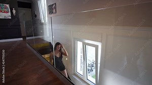 Beautiful woman walking out of bedroom down staircase in luxury villa