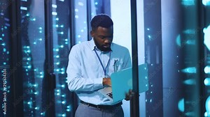 African IT engineer using notebook inspecting super computers network and data servers rack in futuristic data storage center room. Concept of digital technologies and future.