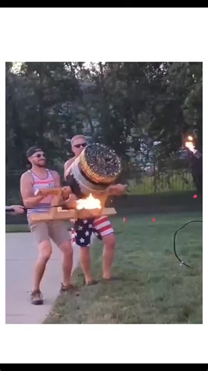 @crazy_trends08 on Instagram: "This instagram post shares a 31-second video of men in a backyard, dressed in American flag shirts and shorts, igniting a homemade barrel cannon that launches fireworks with massive flames and smoke bursts during what appears to be a holiday celebration. Posted on December 19, 2025, by @Crazy_Videozzz —a account specializing in viral stunt videos—it has amassed over 2.5 million views, 21,000 likes, and 183 replies, many humorously linking the reckless display to me