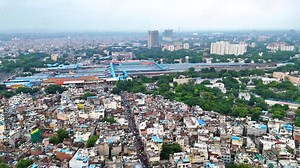 Drone view of New Delhi’s cityscape with a prominent train station in the background. The transportation hub reflects the vibrant energy and complexity of India’s capital.