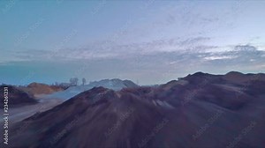 Flying low and slow over construction site sand piles, drone perspective view with motion blur, dirty and wet industrial site, aerial footage. Shot with Gopro Hero 5 black 2.7K.