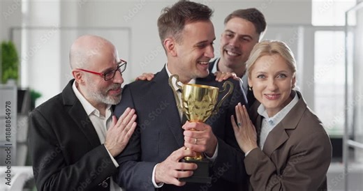 Team colleagues congratulate winner with trophy award. Businessman praised in the office as colleagues show applause, marking success and shared celebration. Team win and recognition concept.