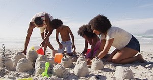 African american parents and their children playing with sand on the beach