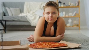 boy doing push-UPS from the floor where the pizza is