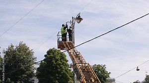 Municipal worker, led lights, replace light bulb. Street light repair work, where workers who is wearing personal protective equipment is repairing light pole lamp at height, replacing led lights