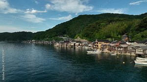 Entering harbor towards traditional waterside boathouses on beautiful day