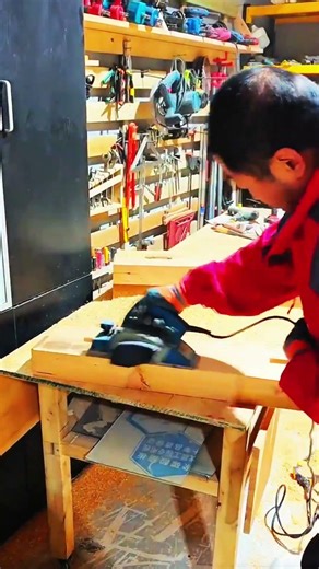 Wood shavings scatter—electric planer smooths timber clean.