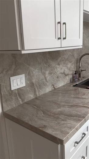 Taj Mahal kitchen countertop with a full backsplash as well as a small island #quartzitecountertops #installation #tajmahalquartzite