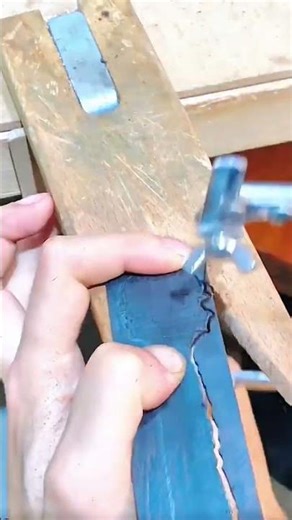 Sawing blue wax block with jeweler’s tool