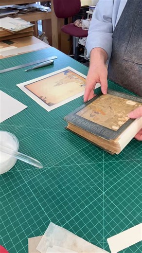 I’m replacing a missing endpaper on this children’s book. The back board image was copied onto similar paper, then trimmed and tipped back onto the book. #bookbinding #bookconservation #bookrepair #endpaper #bookarts #torontobookarts | Big River Bindery