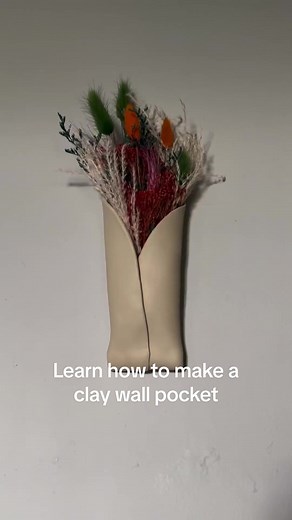 💐 Make your own Clay Wall Pocket Tutorial 💐 • Roll out a slab of clay, about a 1/4 inch thick • Trim the slab to be somewhat symmetrical • Smooth the edges using the sponge included in your pottery kit • Fold the sides of your slab inward and overlap them • Where you want the clay to attach to itself - score (scratch criss-cross lines) with your pointy wooden tool, add water, and press the clay together • Fold the bottom opening towards the back • Trim off excess clay • Attach/smooth the back 