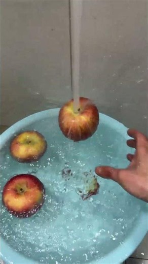 Apple appears to float beneath running water physics demonstration in Shandong, China