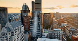 Flight among the high-rise complex of buildings in Boston downtown. Setting sun light reflects in the windows of the skyscrapers.