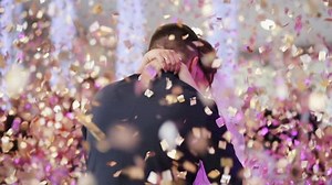 Young beautiful bride and groom dancing first dance at the wedding party shrouded by confetti. Wedding bouquet. Feel happy.