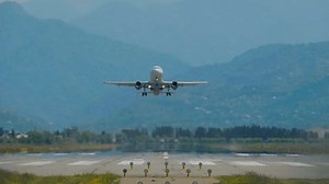 Slow motion, front view: large passenger airplane, airliner is taking off from a runway, gaining altitude. Transportation, departure, journey, flight and tourism concept