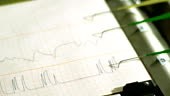 The pens of a polygraph machine record on a printout the results of a...