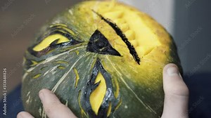Handheld shot of woman's hands carving scary and funny jack-o'-lantern face on a pumpkin with black marker pen. Carving face on a pumpkin for halloween Stock Video