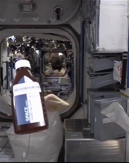 Astronaut eating bread with honey in spaceIn zero gravity, honey forms a floating sphere, showing how surface tension shapes liquids in space