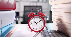 Red alarm clock for ten o'clock on desktop with documents. Overtime and time management concept