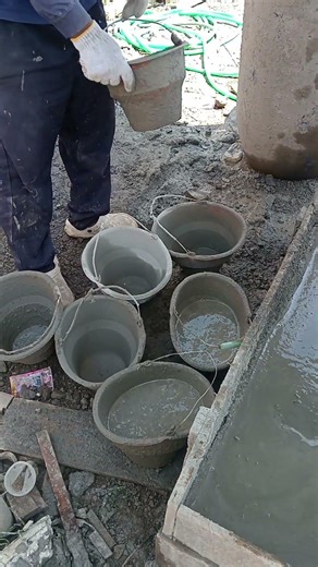 Traditional construction methods: pouring concrete into buckets.