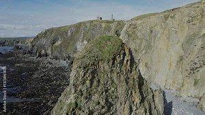 Ireland landscapes Drone rising behind seastack to reveal ruins and landscape of Co. Waterford Ireland epic locations