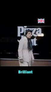 🌳💡🤣 Rowan Atkinson: Lamppost Classic Scene! Before Mr Bean and Blackadder, Rowan Atkinson was already perfecting the art of visual comedy on Not the Nine O’Clock News. The setup is pure brilliance: first, he bumps into a tree. Then, in a follow-up sketch, he faces a lamppost — this time he dodges it, smirks at the camera, and looks like he’s won. But just as he walks on… he disappears straight down a hole. It’s the timing, the escalation, and that cheeky look to the audience that make it unfo