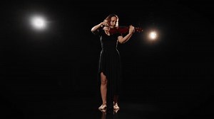 Full-length portrait of barefoot woman musician playing violin in darkness. Enjoy classical music concert and contemporary art performance, inspired female person performing romantic melody on stage