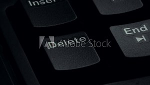 Pressing the delete key on a computer keyboard. close-up