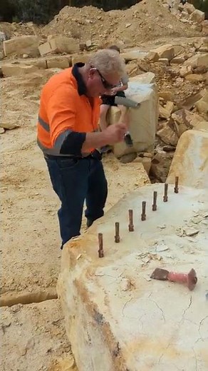 splitting stone using plug and feathers.