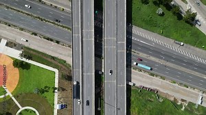 Drone photos of the interchange of a bridge over a road with cars passing by