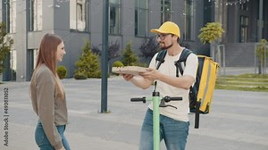 Pizza Delivery. The girl ordered the delivery of pizza. Cheerful handsome young delivery guy holding boxes with hot pizza. Friendly Delivery Man Handing Pizza To A Customer.