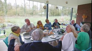 happy senior people group swinging all together at the food table - mature friends singing songs at a dinner party - lifestyle concept older people having fun at indoor lunch
