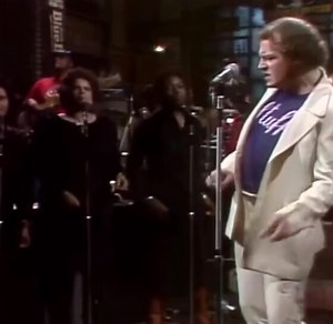 In 1976 on Saturday Night Live, Joe Cocker performed as the musical guest when John Belushi suddenly appeared beside him. Belushi delivered his now-famous exaggerated impersonation, mimicking Cocker.