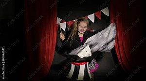 Girl circus performer shows a trick with a hat and a rabbit in the spotlight. High quality 4k footage