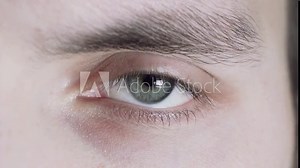 Close-up of a male gray eye. The man blinks, the pupil expands and narrows.
