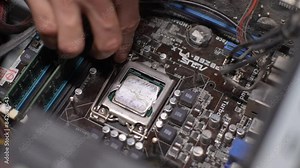 Technician opening CPU slot to remove old dried thermal paste and apply new thermal paste. Concept of service for repair and cleaning of computer equipment. Shooting in slow motion.