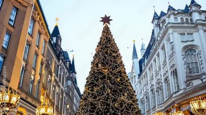 beautifully decorated Christmas tree stands tall in a festive city street, surrounded by historic buildings and lit lanterns