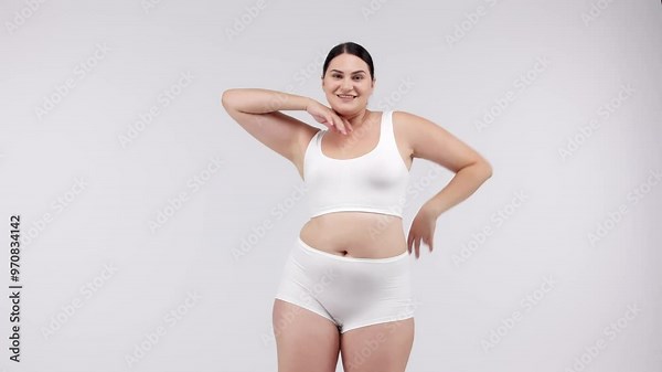 Woman measuring her body with a tape measure on a light background. Perfect for promoting weight loss programs and fitness results, inspiring a healthy lifestyle.