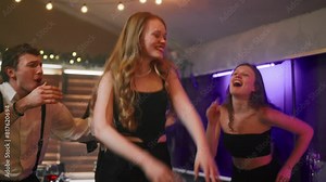 Girl dancing in a club in the crowd friends. Cheerful students dancing having fun, birthday celebrate at night party in bar club. Youth lifestyle, female liberation, clubbing, dance battle concept.