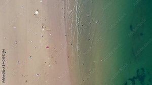 Aerial footage of the beautiful beach of Whitby in the UK, North Yorkshire showing a top down drone view of people relaxing and playing on the sandy beaches on a hot sunny day in the summer time Stock Video